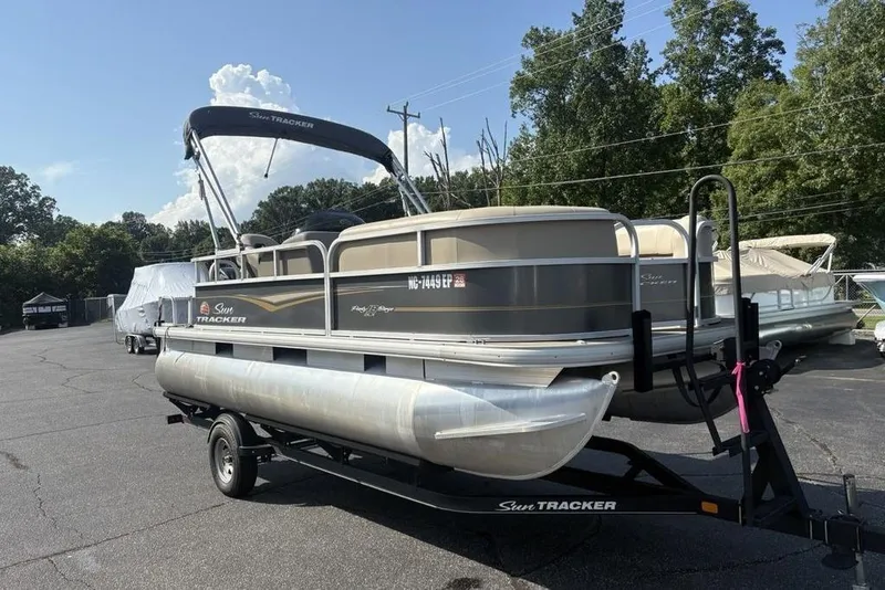 Slide: The Image of 2021 Sun Tracker Party Barge® 18 DLX pontoon boat on trailer, parked outdoors. - 4