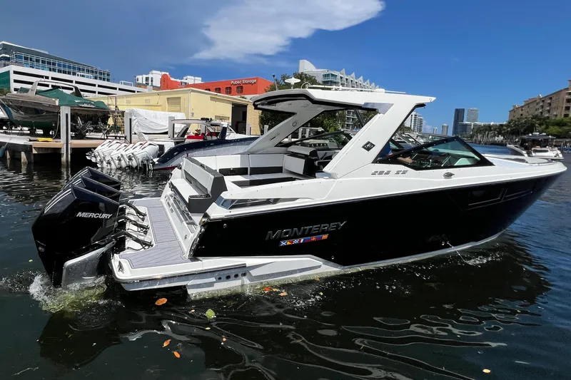 Slide: The Image of 2023 Monterey 385 Super Sport boat docked in a marina, featuring sleek design and Mercury engines. - 10