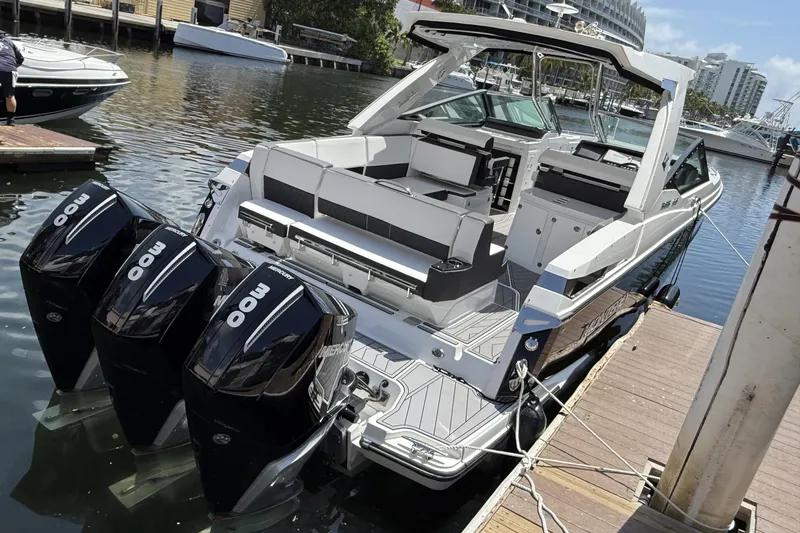 Slide: The Image of 2023 Monterey 385 Super Sport boat docked with triple 300 horsepower engines. - 13