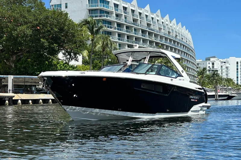 Slide: The Image of 2023 Monterey 385 Super Sport boat on water near modern buildings and trees. - 3