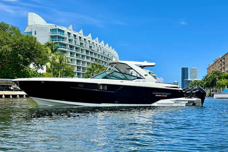 Slide: The Image of 2023 Monterey 385 Super Sport boat on water, modern architecture in background. - 4