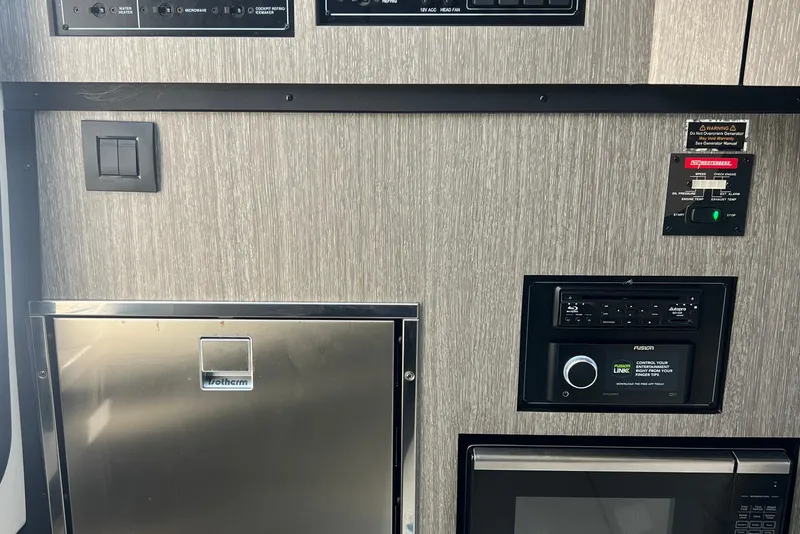 Slide: The Image of Control panel and appliances inside a 2023 Monterey 385 Super Sport boat. - 44