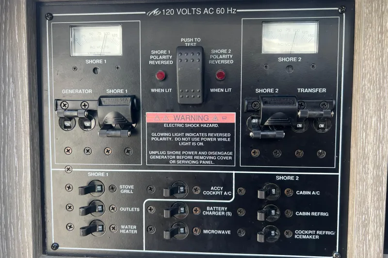 Slide: The Image of 2023 Monterey 385 Super Sport electrical panel with shore power and generator controls. - 46