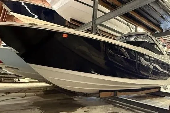 Slide: The Image of 2023 Monterey 385 Super Sport boat in storage, sleek design, black and white exterior. - 52