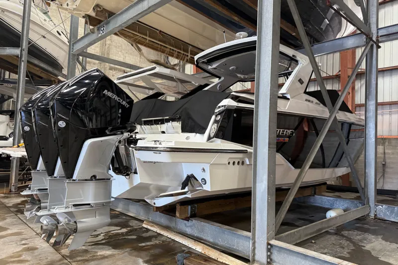 Slide: The Image of 2023 Monterey 385 Super Sport boat with triple Mercury engines in storage. - 53