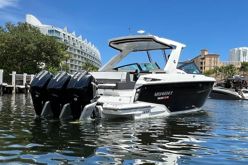 Slide: The Image of 2023 Monterey 385 Super Sport boat with triple engines on a sunny waterfront. - 55