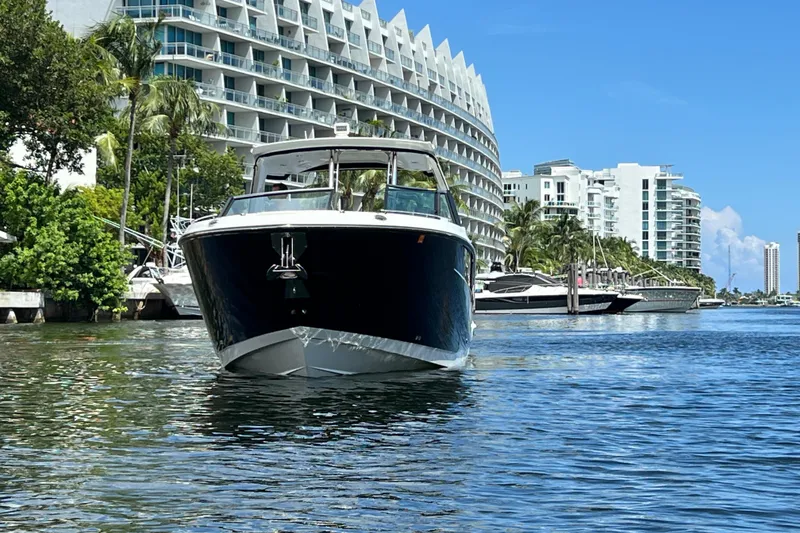 Slide: The Image of 2023 Monterey 385 Super Sport boat on water near modern buildings and palm trees. - 58