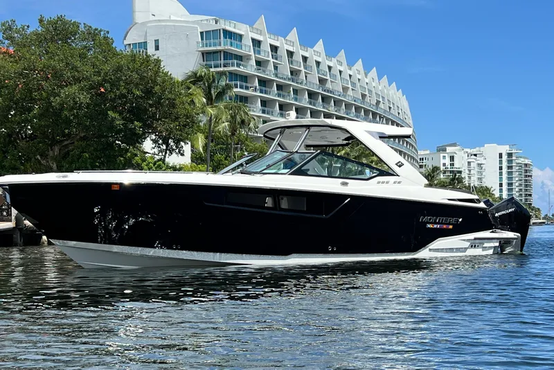 Slide: The Image of 2023 Monterey 385 Super Sport boat on water, modern buildings in background. - 59