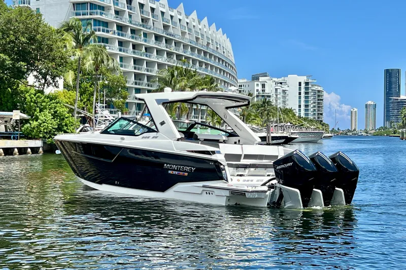 Slide: The Image of 2023 Monterey 385 Super Sport boat on a scenic waterfront with modern buildings. - 60