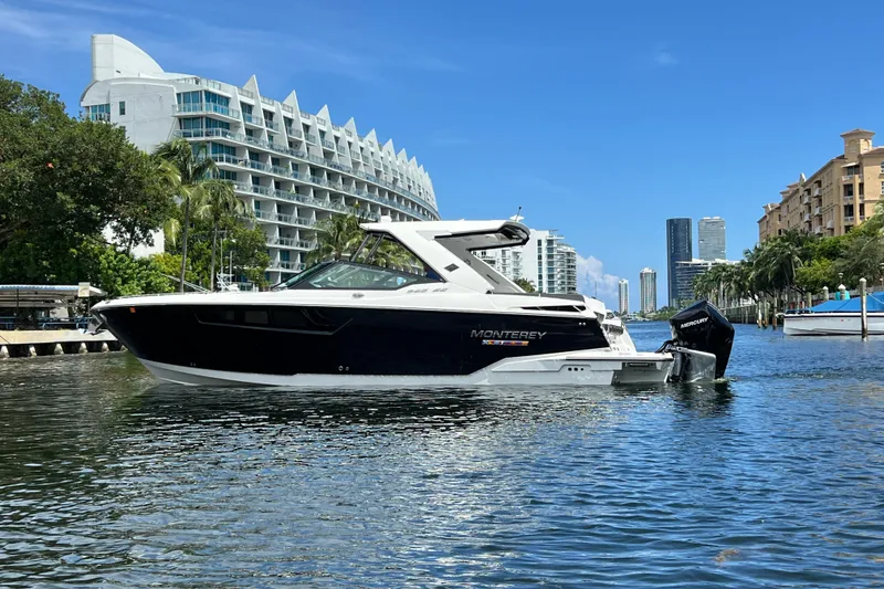 Slide: The Image of 2023 Monterey 385 Super Sport boat cruising in a scenic urban waterway. - 7