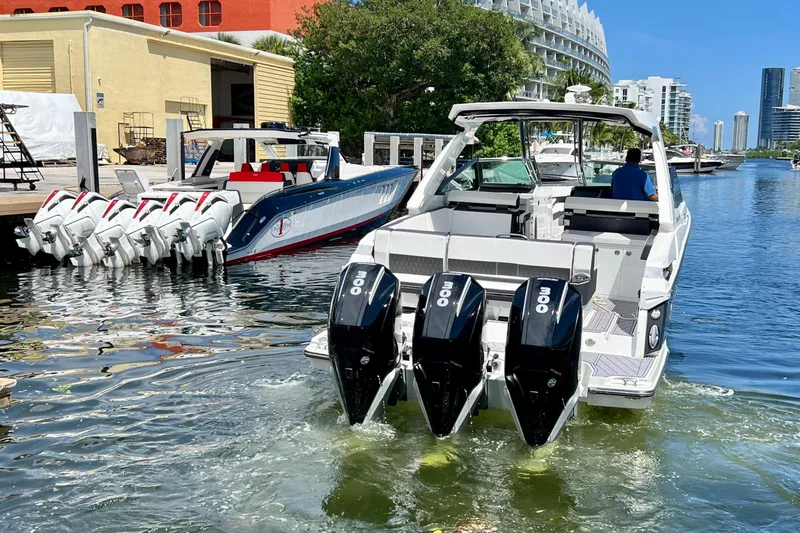 Slide: The Image of 2023 Monterey 385 Super Sport boat with triple outboard engines docked in a marina. - 9