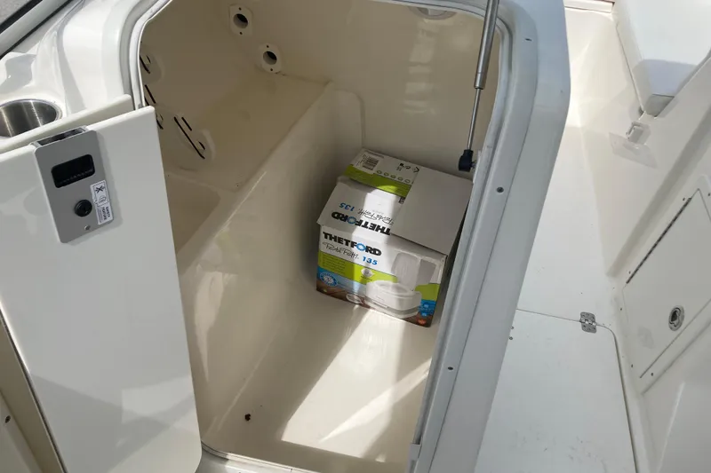 Slide: The Image of 2022 Key West 239 DFS boat storage compartment with Thetford portable toilet box. - 11