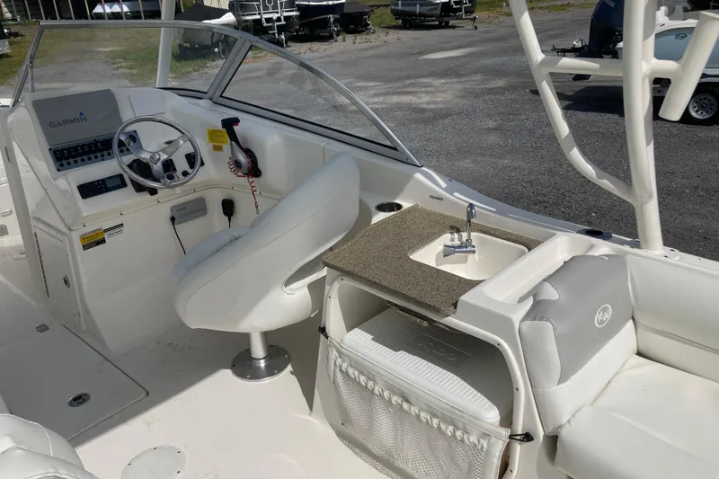 Slide: The Image of 2022 Key West 239 DFS boat interior with steering wheel, Garmin system, and sink. - 20