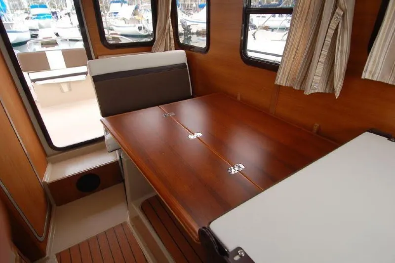 Slide: The Image of Interior of 2016 Ranger Tugs R25 SC with wooden table and seating. - 12