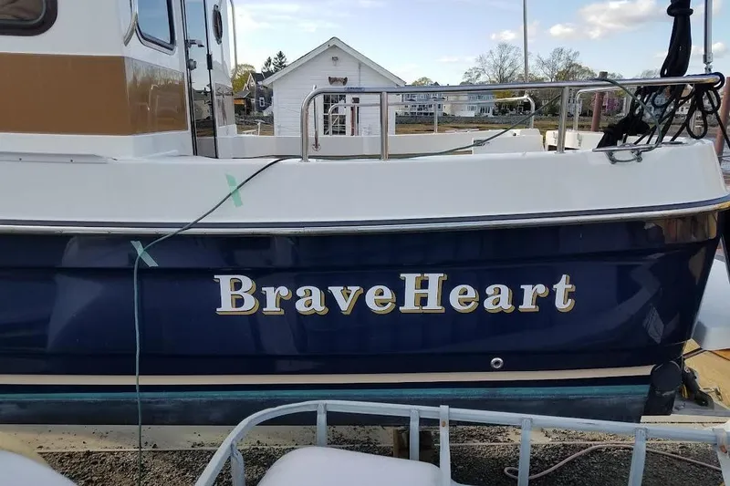 Slide: The Image of 2016 Ranger Tugs R25 SC boat named "BraveHeart" docked at a marina. - 2