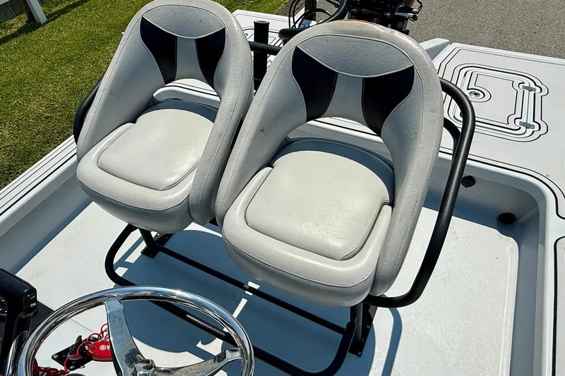 Slide: The Image of Two white seats on a 2017 Majek M2 ILLUSION boat, with a steering wheel visible. - 9
