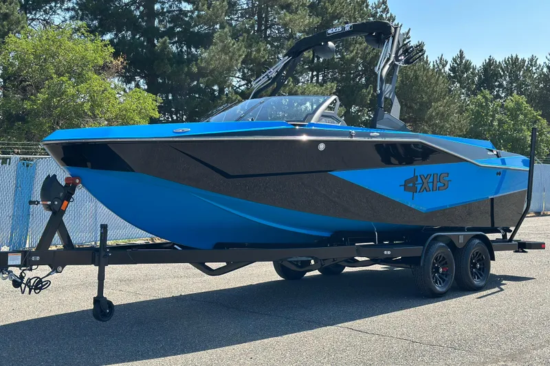 The Image of 2026 Axis T235 boat in blue and black on a trailer, parked outdoors. - 0