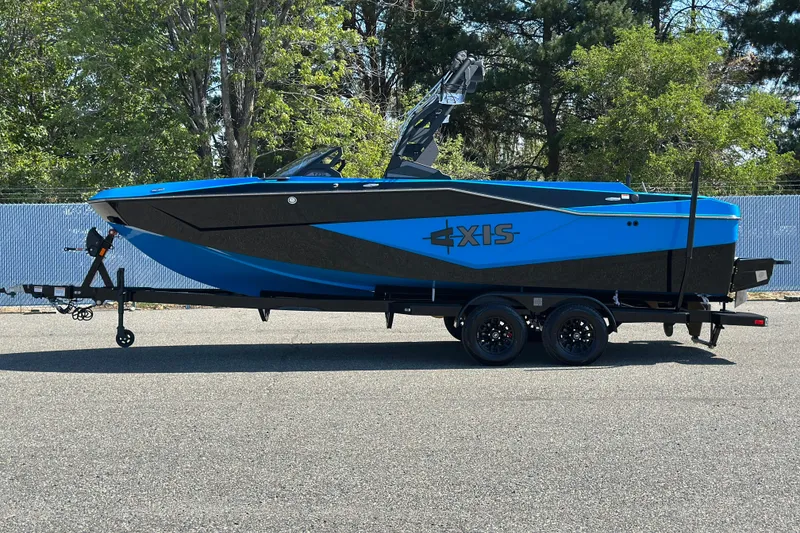 Slide: The Image of 2026 Axis T235 boat on trailer, blue and black design, parked outdoors. - 1