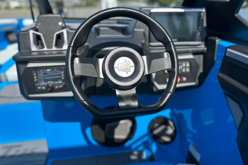 Slide: The Image of Steering wheel and dashboard of 2026 Axis T235 boat, featuring modern controls and displays. - 14