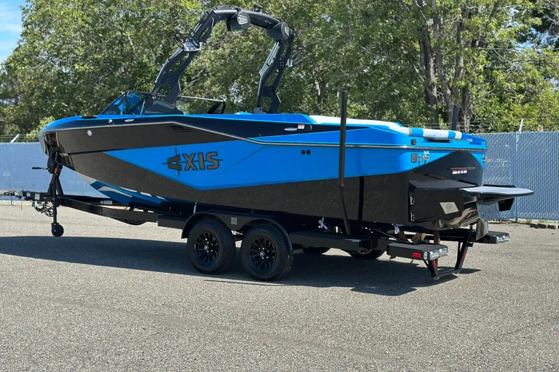 Slide: The Image of 2026 Axis T235 boat in vibrant blue on a trailer, parked outdoors. - 2