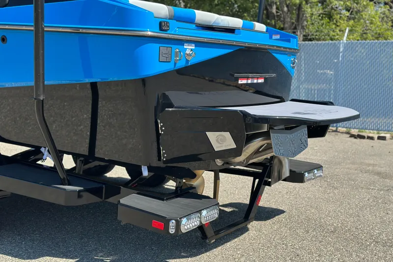 Slide: The Image of 2026 Axis T235 boat rear view with blue and black design, featuring swim platform. - 3