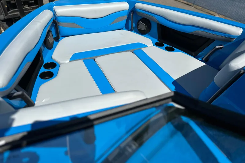 Slide: The Image of 2026 Axis T235 boat interior with blue and white seating, cup holders, and sleek design. - 5