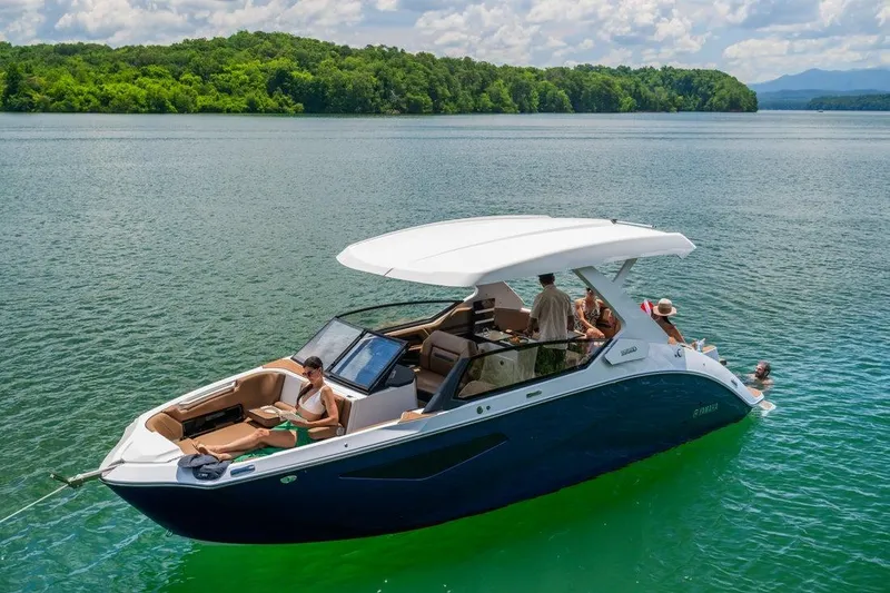 Slide: The Image of 2026 Yamaha Boats 295SD on a serene lake with passengers enjoying the view. - 1