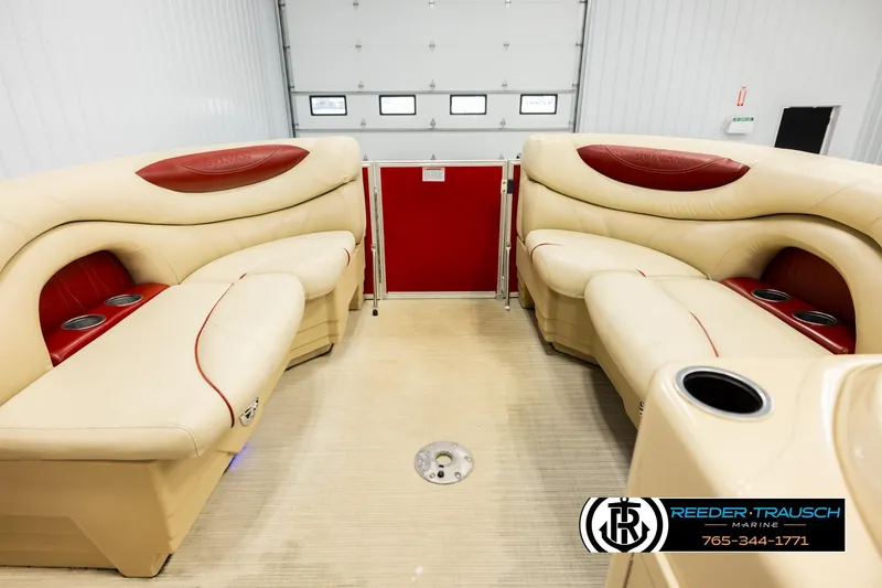 Slide: The Image of 2017 Sylvan 818 Mirage CR interior with beige and red seating, cup holders, and spacious layout. - 18