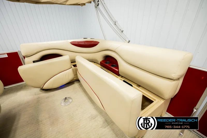Slide: The Image of 2017 Sylvan 818 Mirage CR boat interior with beige and red seating, cup holders, and storage. - 23