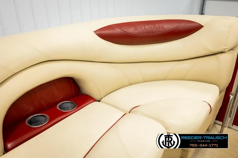 Slide: The Image of 2017 Sylvan 818 Mirage CR boat interior with beige and red seating, featuring cup holders. - 35