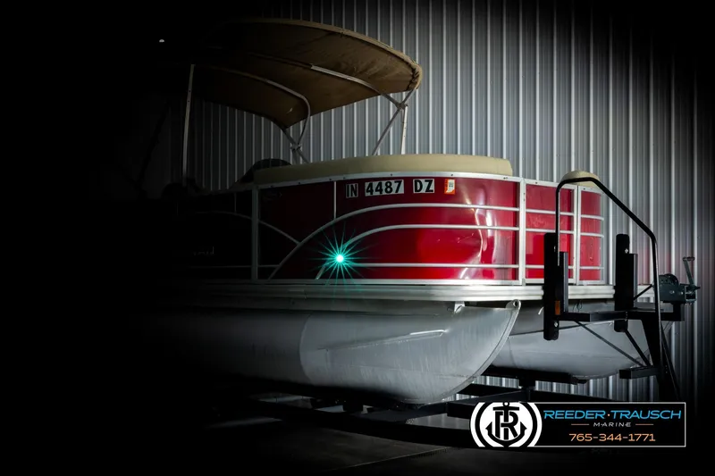 Slide: The Image of 2017 Sylvan 818 Mirage CR pontoon boat in storage, featuring a red exterior. - 4