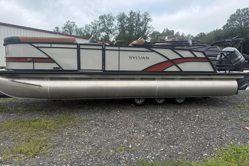 The Image of 2026 Sylvan L-3 DLZ DH pontoon boat on gravel, side view. - 1