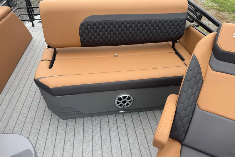 Slide: The Image of 2026 Sylvan L-3 DLZ DH boat interior with tan and gray seating, featuring a speaker. - 12