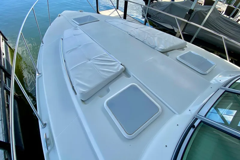 Slide: The Image of 2004 Formula 37 PC yacht deck with cushioned seating and hatches, docked by the water. - 10