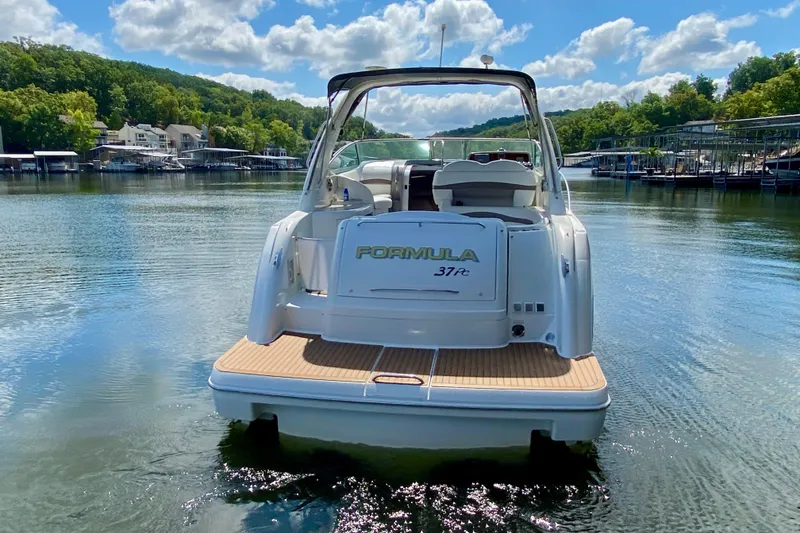 Slide: The Image of 2004 Formula 37 PC boat on a serene lake with lush green surroundings. - 3