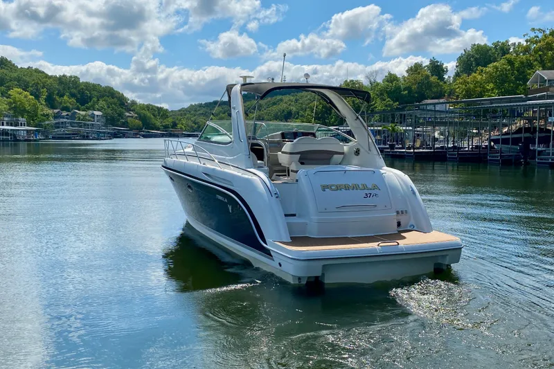 Slide: The Image of 2004 Formula 37 PC boat cruising on a serene lake under a partly cloudy sky. - 4