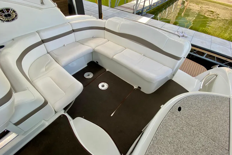 Slide: The Image of 2004 Formula 37 PC boat interior with white seating and brown accents near water. - 8