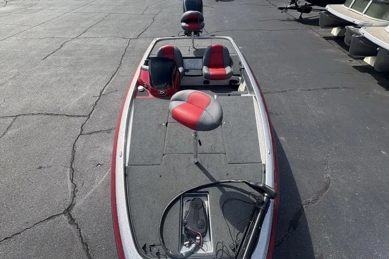 Slide: The Image of 2008 Skeeter ZX190 fishing boat with red and gray seating, parked on asphalt. - 28