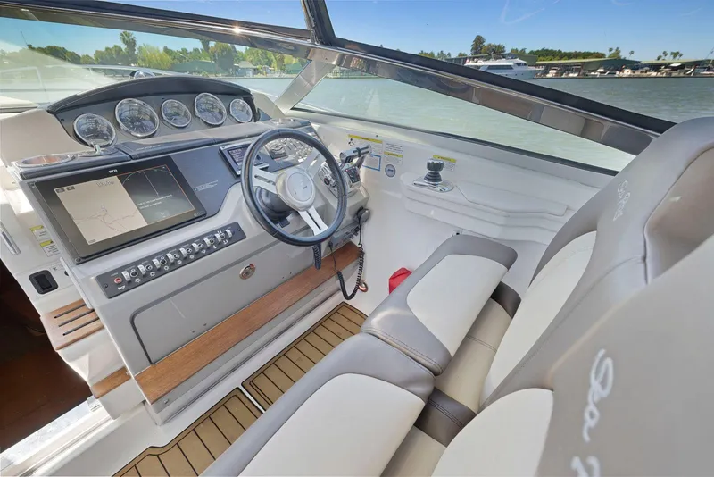 Slide: The Image of Interior view of 2014 Sea Ray 350 Sundancer boat cockpit with steering wheel and navigation controls. - 18