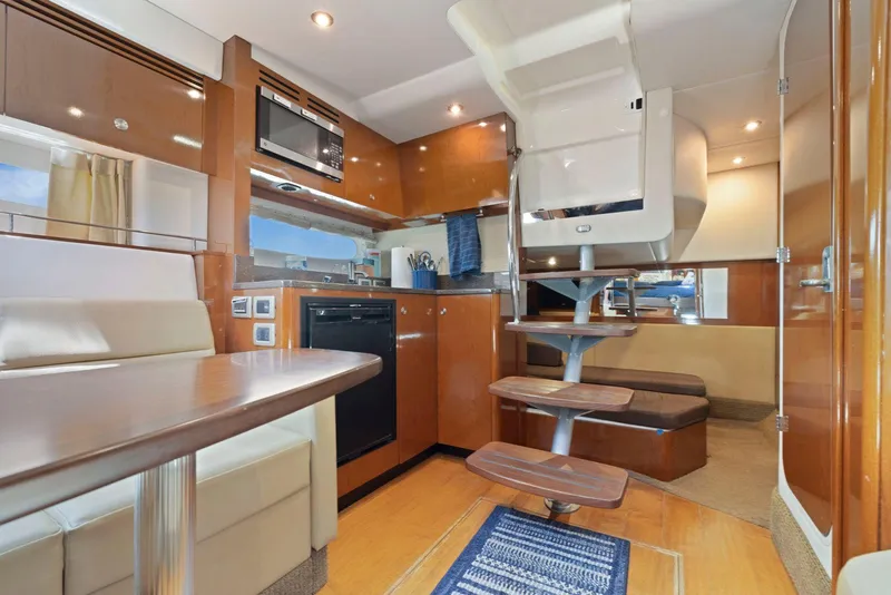 Slide: The Image of Interior of 2014 Sea Ray 350 Sundancer yacht with modern kitchen and dining area. - 27