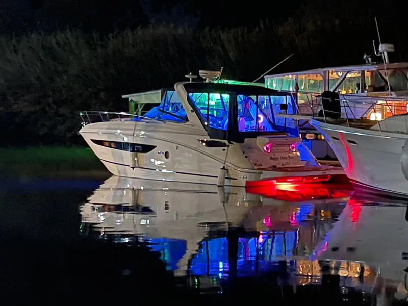 Slide: The Image of 2014 Sea Ray 350 Sundancer yacht illuminated with colorful lights, docked at night. - 37