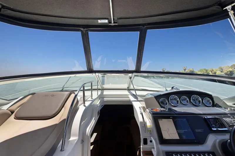 Slide: The Image of 2014 Sea Ray 350 Sundancer helm with navigation controls and clear ocean view. - 9