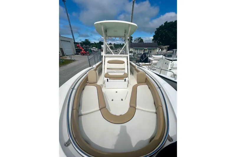 Slide: The Image of 2021 Pioneer 222 Islander boat with tan seating and T-top under a blue sky. - 15