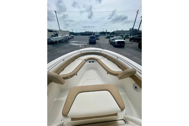 Slide: The Image of 2021 Pioneer 222 Islander boat interior with tan seating, parked in a lot. - 17