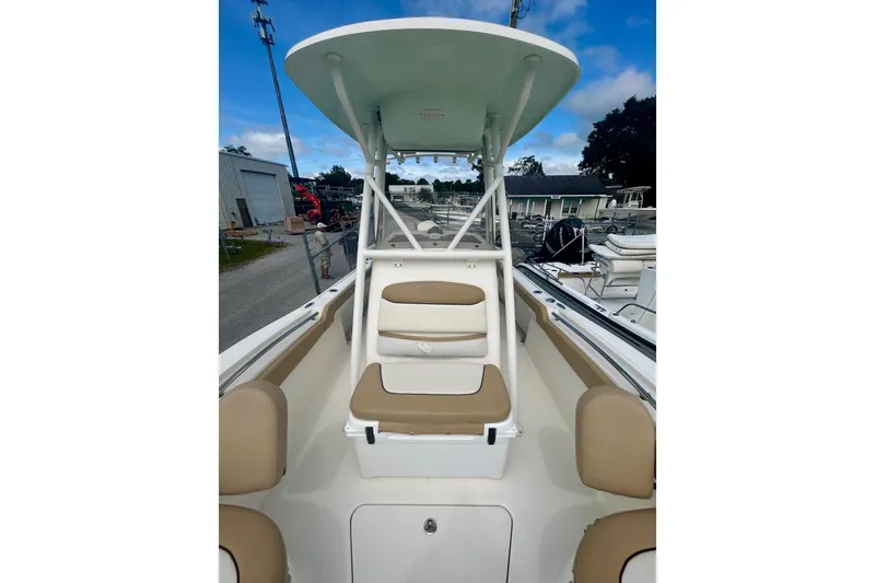 Slide: The Image of 2021 Pioneer 222 Islander boat with seating and canopy, docked outdoors. - 4
