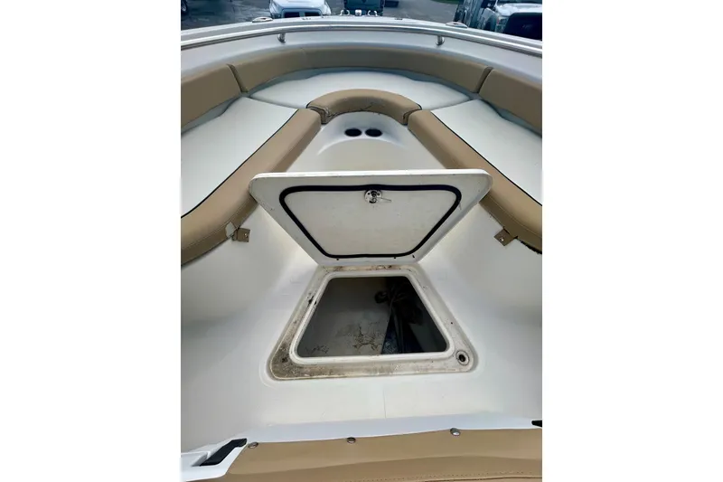 Slide: The Image of 2021 Pioneer 222 Islander boat with open storage compartment and tan seating. - 6