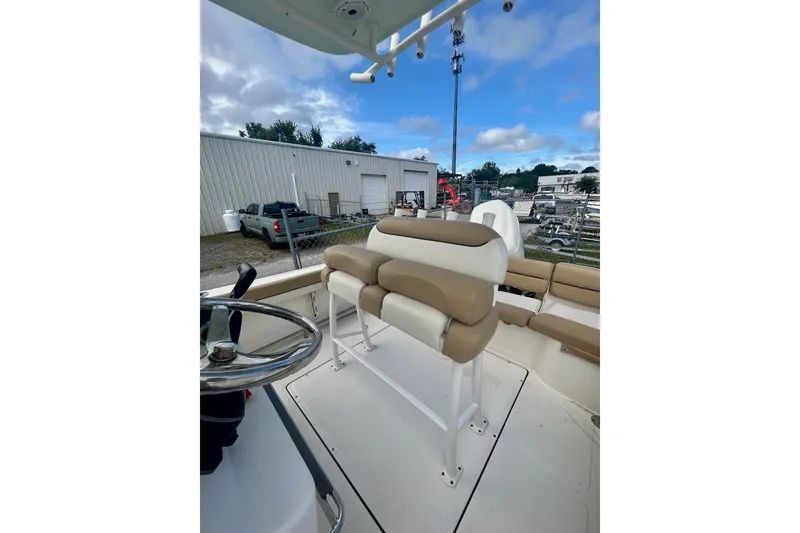 Slide: The Image of 2021 Pioneer 222 Islander boat interior with beige seating and steering wheel. - 8