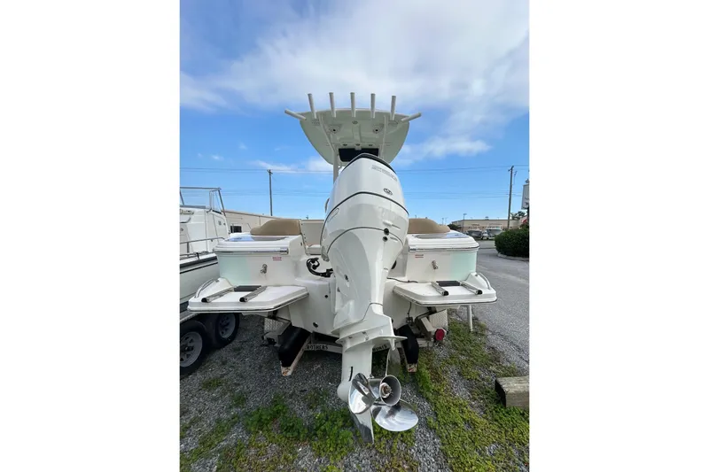 Slide: The Image of 2021 Pioneer 222 Islander boat, rear view with outboard motor, parked on gravel. - 9