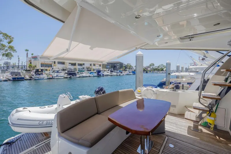 Slide: The Image of 2015 Prestige 500FB yacht deck with seating, table, and marina view. - 2