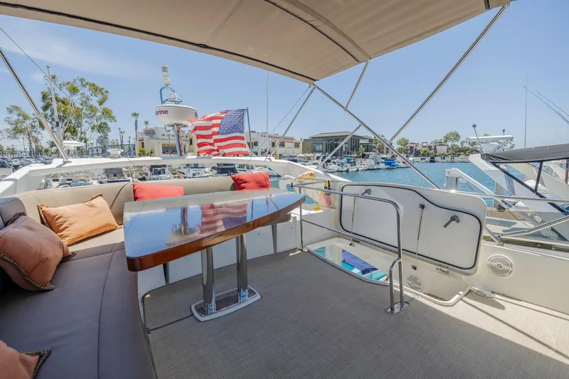 Slide: The Image of Luxurious 2015 Prestige 500FB yacht deck with seating, table, and American flag. - 28